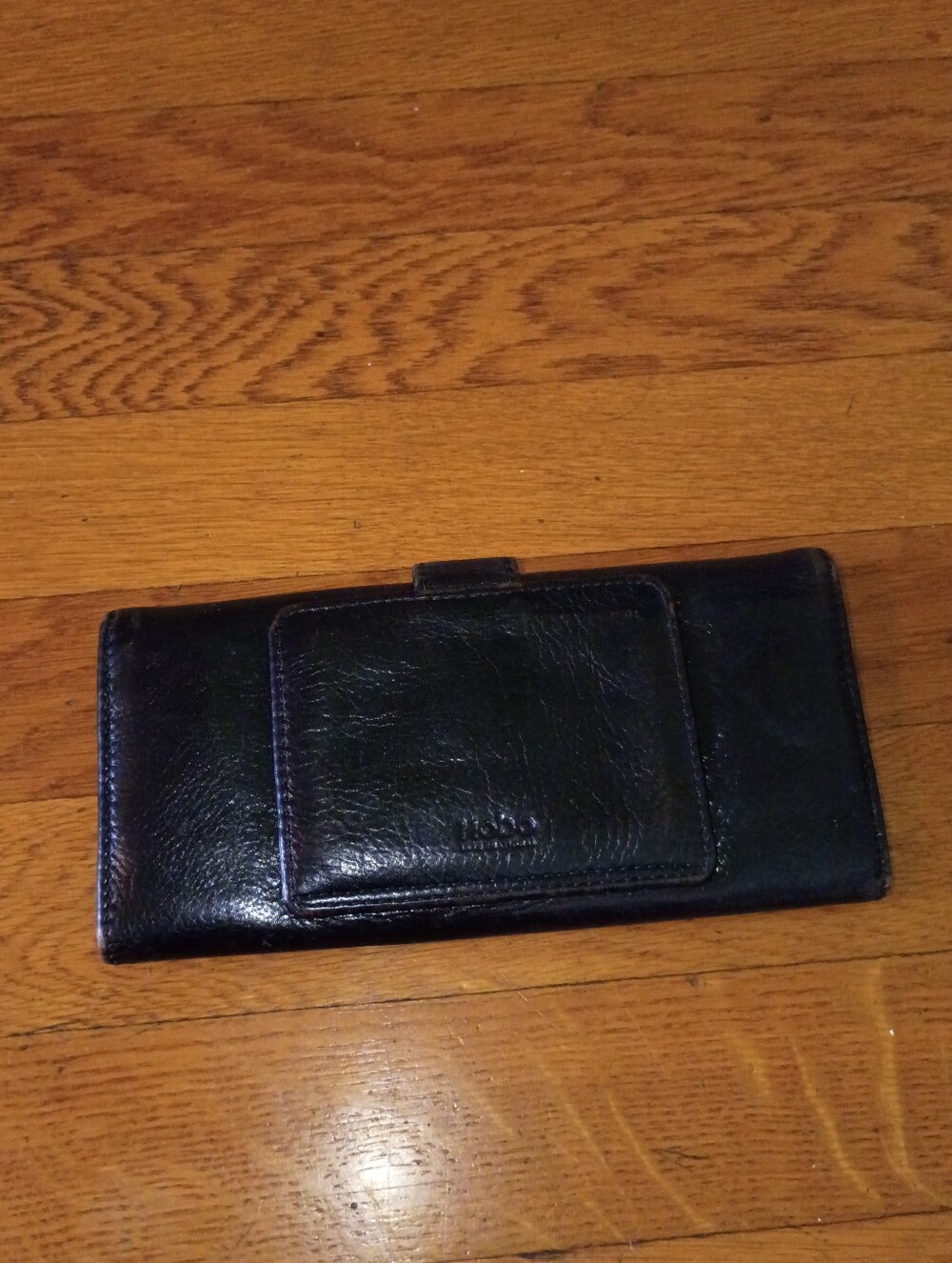 black leather hobo wallet with red lining and magnetic clasp